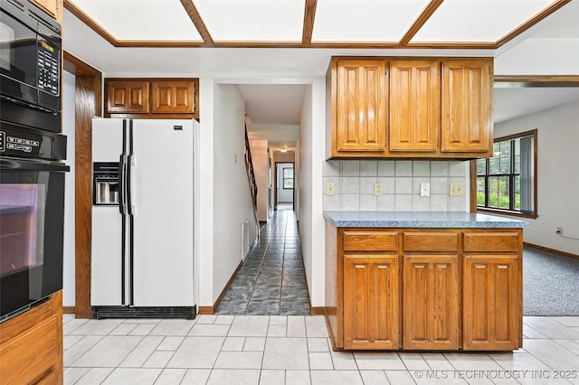 32069 Meadow Ln, Mannford, OK 74044 - kitchen featuring black appliances, light tile patterned floors, brown cabinets, and backsplash