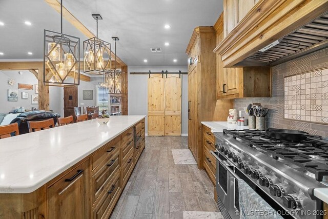 2724 Lark Rd, Kingston, OK 73439 - kitchen with double oven range, custom exhaust hood, a barn door, light wood-type flooring, and tasteful backsplash