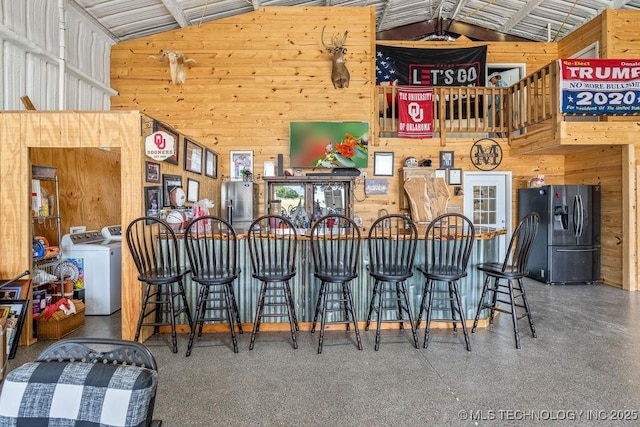 2724 Lark Rd, Kingston, OK 73439 - indoor bar with stainless steel fridge, lofted ceiling, washer / dryer, and wood walls