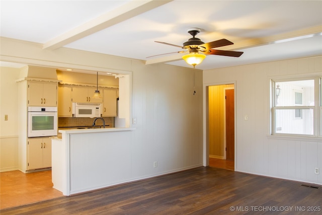 6740 E 51st Pl, Tulsa, OK 74145 - unfurnished living room with wood finished floors, a ceiling fan, and beamed ceiling