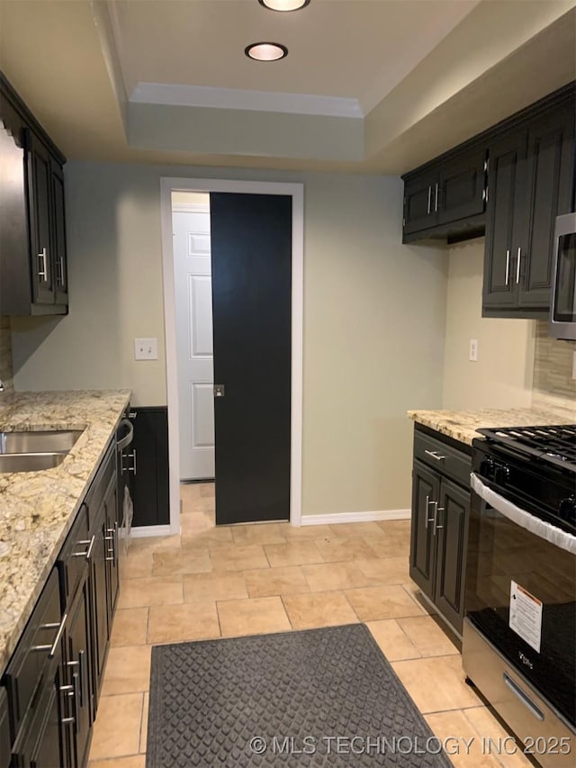 11810 E 83rd St, Owasso, OK 74055 - kitchen with gas range, a tray ceiling, dark cabinetry, light stone counters, and recessed lighting