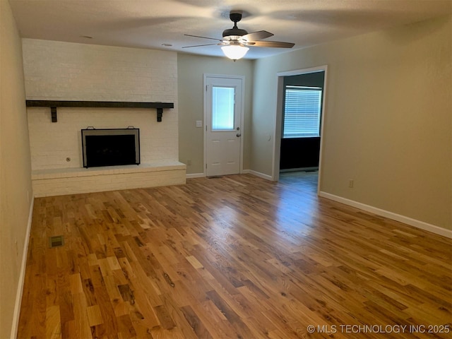 11810 E 83rd St, Owasso, OK 74055 - unfurnished living room featuring a fireplace, a ceiling fan, and wood finished floors