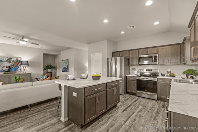 7420 E 160th Pl S, Bixby, OK 74008 - kitchen with stainless steel appliances, open floor plan, light wood-type flooring, dark brown cabinetry, and recessed lighting