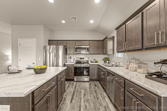7420 E 160th Pl S, Bixby, OK 74008 - kitchen with appliances with stainless steel finishes, dark brown cabinetry, lofted ceiling, light wood-style flooring, and recessed lighting