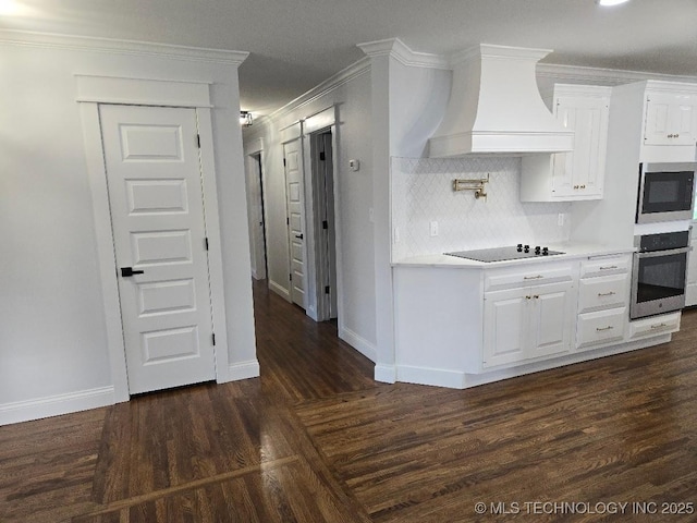 6706 E 28th Pl, Tulsa, OK 74129 - kitchen with custom range hood, appliances with stainless steel finishes, white cabinets, crown molding, and dark wood-type flooring