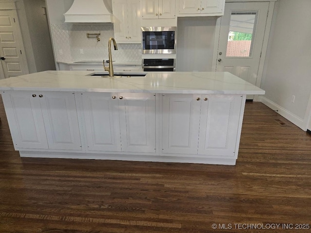 6706 E 28th Pl, Tulsa, OK 74129 - kitchen featuring stainless steel appliances, custom range hood, dark wood finished floors, white cabinets, and tasteful backsplash