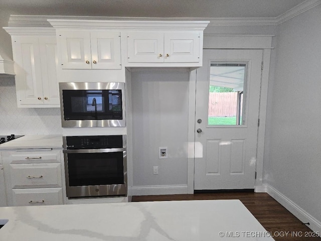 6706 E 28th Pl, Tulsa, OK 74129 - kitchen with stainless steel appliances, ornamental molding, dark wood-style floors, white cabinets, and decorative backsplash