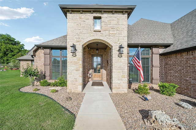 20905 S Windsor Ave, Claremore, OK 74019 - property entrance featuring a shingled roof, a yard, brick siding, and stone siding