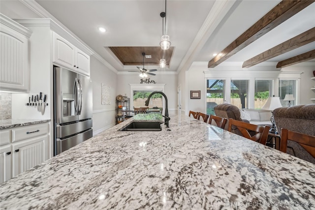 20905 S Windsor Ave, Claremore, OK 74019 - kitchen with stainless steel refrigerator with ice dispenser, open floor plan, light stone countertops, plenty of natural light, and ornamental molding