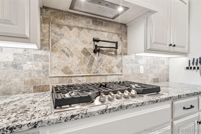 20905 S Windsor Ave, Claremore, OK 74019 - kitchen with stainless steel gas stovetop, tasteful backsplash, white cabinets, and exhaust hood
