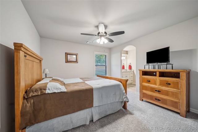 20905 S Windsor Ave, Claremore, OK 74019 - bedroom featuring arched walkways, light carpet, ceiling fan, and ensuite bath