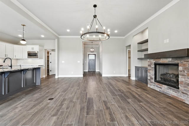 14109 N 72nd E Ave, Collinsville, OK 74021 - kitchen featuring stainless steel microwave, white cabinets, open floor plan, a fireplace, and a chandelier