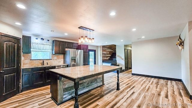 5068 E 188th St S, Warner, OK 74469 - kitchen featuring stainless steel fridge with ice dispenser, decorative backsplash, light wood-style floors, recessed lighting, and hanging light fixtures