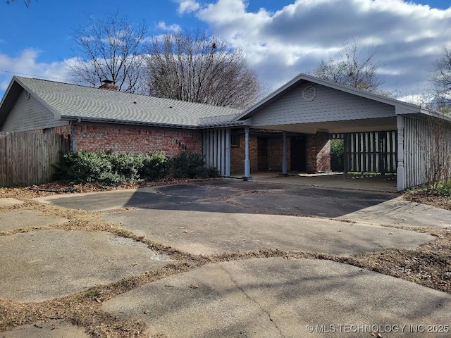 1604 S 5th St, Mcalester, OK 74501 - view of front of home featuring concrete driveway, brick siding, a chimney, and an attached carport