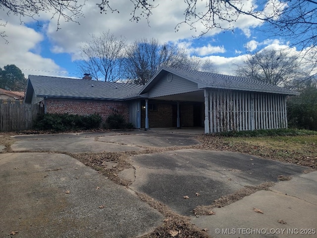 1604 S 5th St, Mcalester, OK 74501 - view of front facade featuring driveway, a chimney, a carport, and brick siding