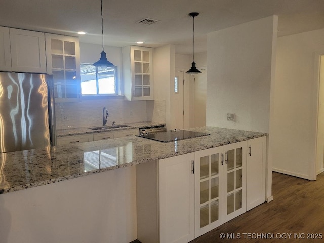 1604 S 5th St, Mcalester, OK 74501 - kitchen featuring freestanding refrigerator, black electric stovetop, backsplash, white cabinets, and recessed lighting