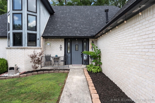 1934 Birnamwood, Miami, OK 74354 - entrance to property with roof with shingles, brick siding, and a lawn