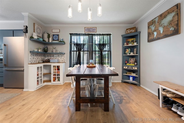 1934 Birnamwood, Miami, OK 74354 - dining space with light wood-style flooring, crown molding, and a textured ceiling