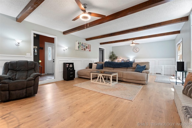 1934 Birnamwood, Miami, OK 74354 - living room with a ceiling fan, a decorative wall, a wainscoted wall, and light wood finished floors