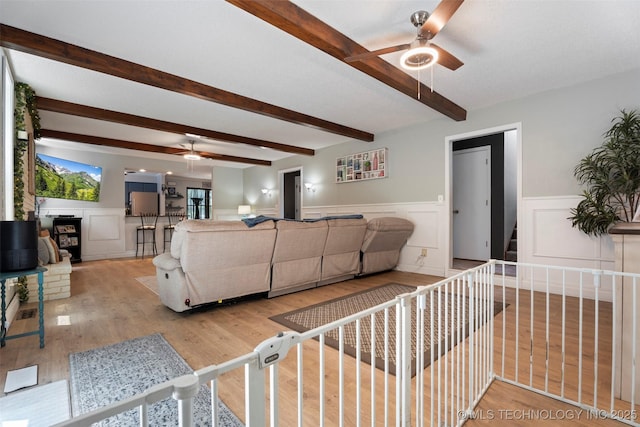 1934 Birnamwood, Miami, OK 74354 - living area with ceiling fan, beam ceiling, wood finished floors, wainscoting, and a decorative wall