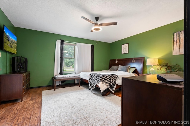 1934 Birnamwood, Miami, OK 74354 - bedroom with wood finished floors, a ceiling fan, and a textured ceiling