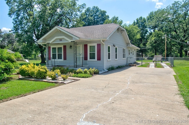 711 S 29th St W, Muskogee, OK 74401 - view of front of home with concrete driveway, covered porch, and roof with shingles