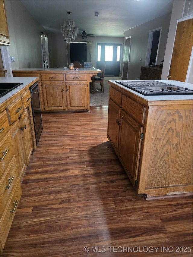617 N 11th St, Pawnee, OK 74058 - kitchen featuring dark wood-style floors, stovetop with downdraft, a chandelier, dishwasher, and a kitchen island