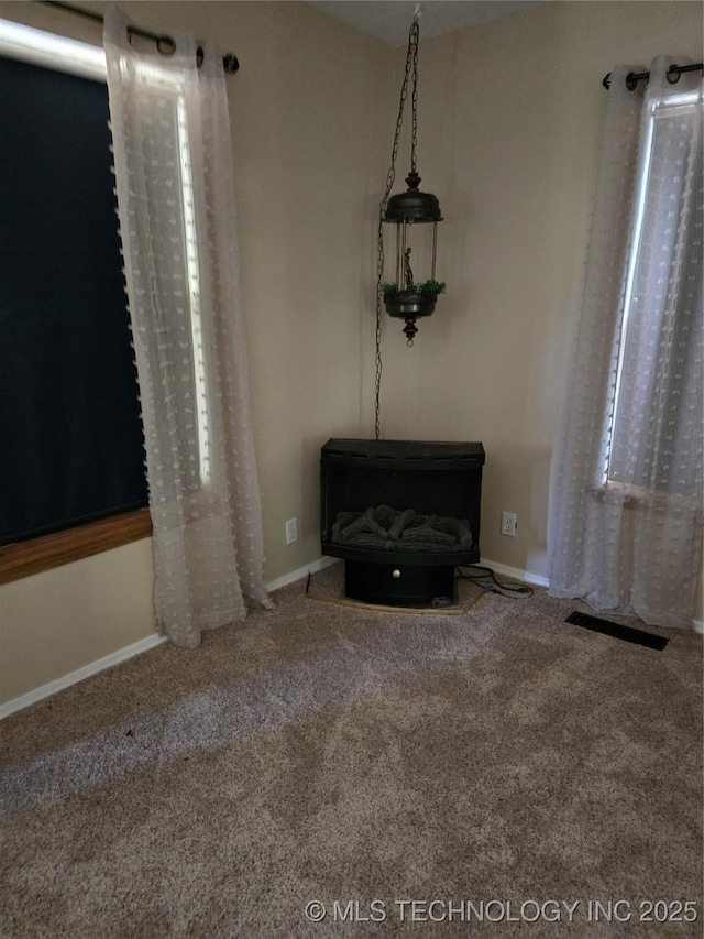 617 N 11th St, Pawnee, OK 74058 - unfurnished room with a wood stove and carpet