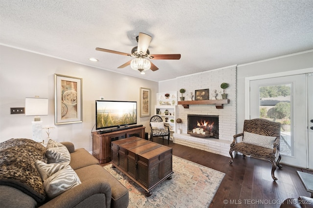 7058 E 52nd Pl, Tulsa, OK 74145 - living room featuring a textured ceiling, ornamental molding, ceiling fan, wood finished floors, and a brick fireplace