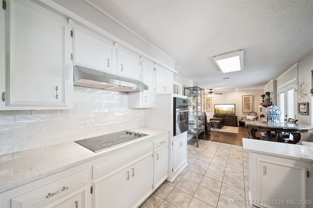 7058 E 52nd Pl, Tulsa, OK 74145 - kitchen with black electric stovetop, under cabinet range hood, stainless steel oven, backsplash, and white cabinetry