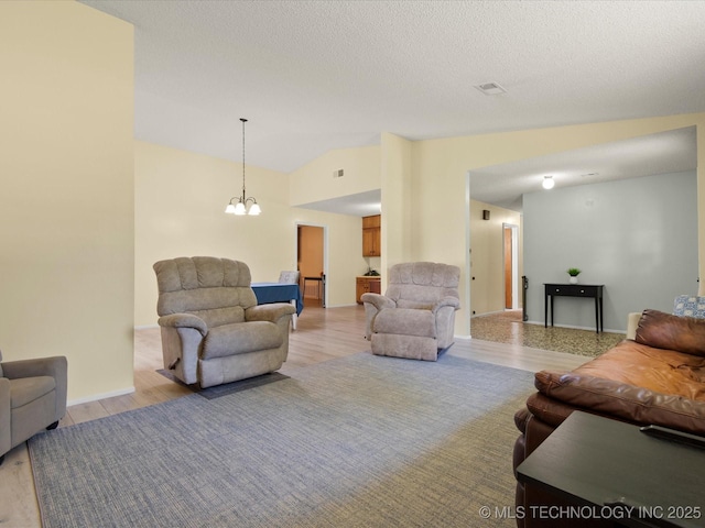 1267 Guinn Ln, Bartlesville, OK 74006 - living area with light wood finished floors, a chandelier, and vaulted ceiling
