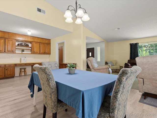 1267 Guinn Ln, Bartlesville, OK 74006 - dining room featuring lofted ceiling, light wood-style floors, and a chandelier