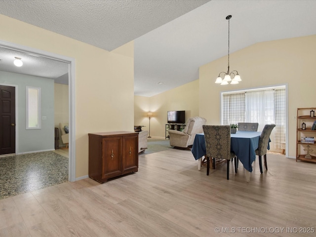 1267 Guinn Ln, Bartlesville, OK 74006 - dining space featuring healthy amount of natural light, light wood-style flooring, vaulted ceiling, and a chandelier