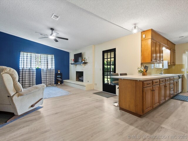 1267 Guinn Ln, Bartlesville, OK 74006 - kitchen featuring open floor plan, light wood-style flooring, light countertops, and a textured ceiling