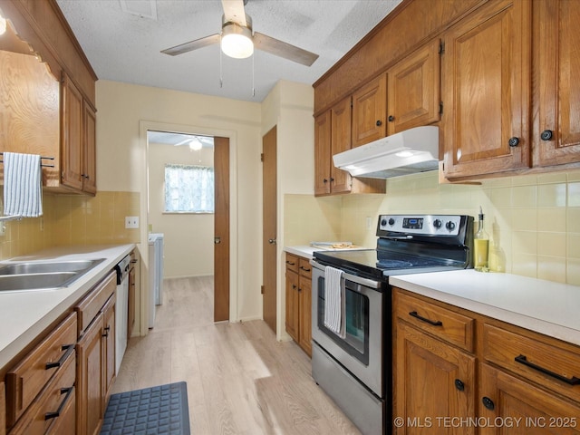 1267 Guinn Ln, Bartlesville, OK 74006 - kitchen featuring under cabinet range hood, stainless steel appliances, ceiling fan, light wood-style floors, and brown cabinets