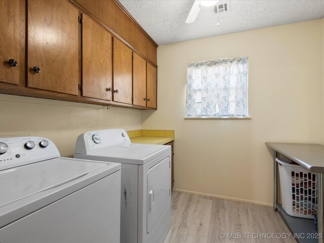 1267 Guinn Ln, Bartlesville, OK 74006 - laundry room featuring washer and dryer, cabinet space, light wood-style flooring, a textured ceiling, and ceiling fan