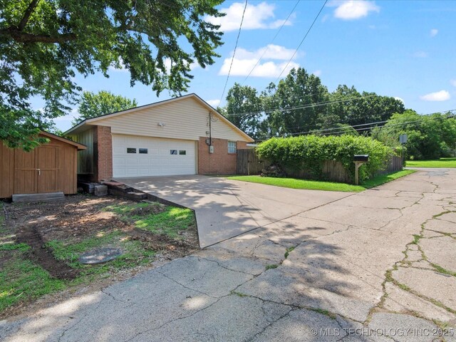 1267 Guinn Ln, Bartlesville, OK 74006 - view of front of house featuring brick siding, an outbuilding, and concrete driveway