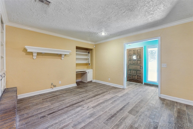 3609 E Scenic Dr, Cushing, OK 74023 - unfurnished living room with wood finished floors, a textured ceiling, ornamental molding, and built in study area