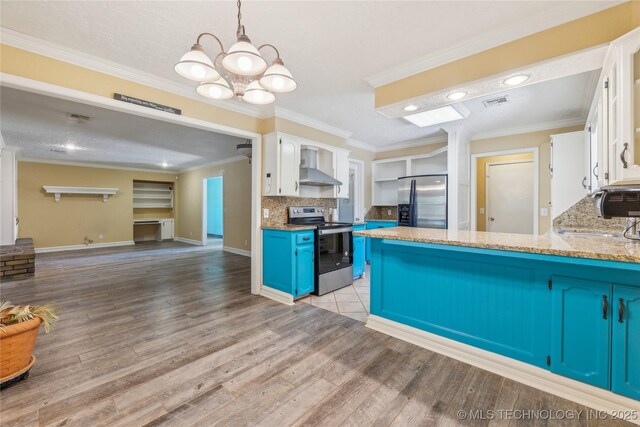 3609 E Scenic Dr, Cushing, OK 74023 - kitchen featuring appliances with stainless steel finishes, blue cabinetry, white cabinetry, a peninsula, and light wood-type flooring
