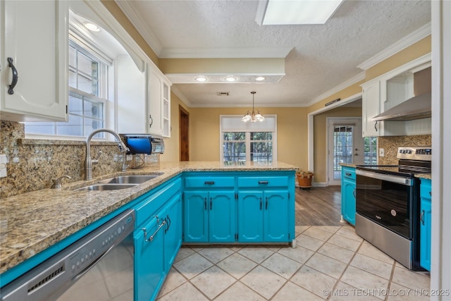 3609 E Scenic Dr, Cushing, OK 74023 - kitchen featuring appliances with stainless steel finishes, blue cabinets, white cabinets, a peninsula, and a textured ceiling