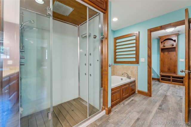3609 E Scenic Dr, Cushing, OK 74023 - full bath featuring wood finished floors, a shower stall, and a bath