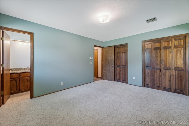 3609 E Scenic Dr, Cushing, OK 74023 - unfurnished bedroom with carpet, two closets, and ensuite bathroom