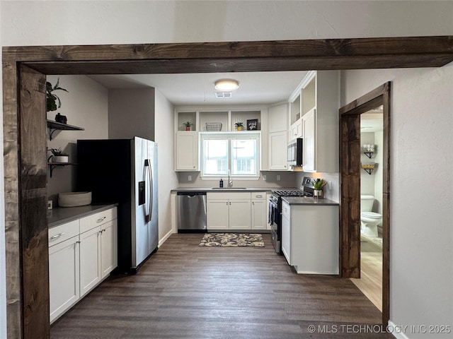 911 E Maple St, Cushing, OK 74023 - kitchen with stainless steel appliances, open shelves, dark countertops, dark wood finished floors, and white cabinets