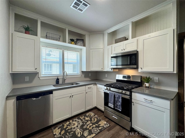911 E Maple St, Cushing, OK 74023 - kitchen featuring stainless steel appliances, dark wood-style flooring, white cabinets, open shelves, and dark countertops