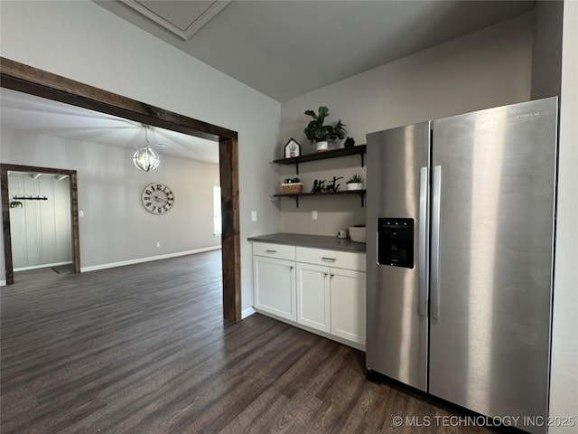 911 E Maple St, Cushing, OK 74023 - kitchen with stainless steel fridge, dark wood-type flooring, dark countertops, white cabinetry, and open shelves