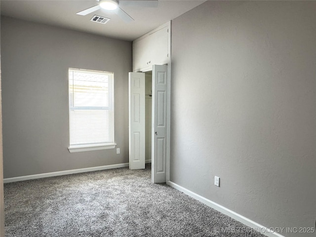 911 E Maple St, Cushing, OK 74023 - unfurnished bedroom featuring carpet, a ceiling fan, and a textured wall
