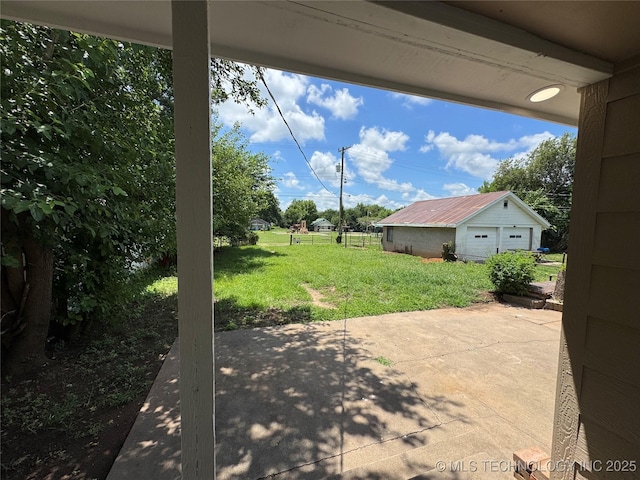 911 E Maple St, Cushing, OK 74023 - view of green lawn featuring a patio area, a garage, and an outdoor structure