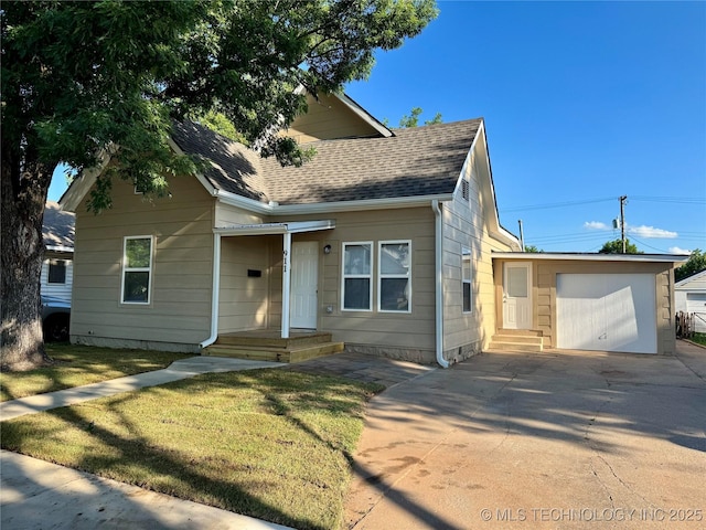 911 E Maple St, Cushing, OK 74023 - bungalow featuring concrete driveway, a shingled roof, a garage, a front lawn, and an outbuilding