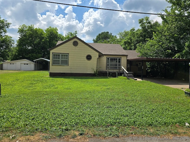 615 11th St, Pawnee, OK 74058 - view of front facade featuring crawl space, a front yard, an outdoor structure, a detached garage, and driveway