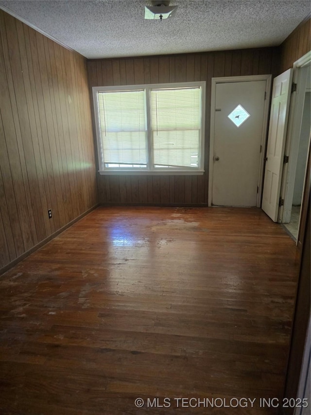 615 11th St, Pawnee, OK 74058 - entrance foyer featuring wood walls, wood-type flooring, and a textured ceiling